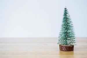 árvore de natal na mesa de madeira com fundo de parede branca foto