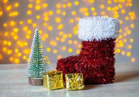 bota de papai noel vermelho na mesa de madeira com fundo claro bokeh foto