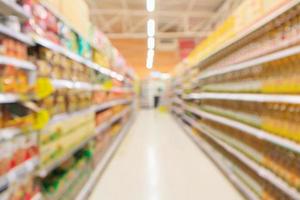 corredor do supermercado com tempero e cozimento de garrafas de óleo vegetal prateleiras de produtos interior desfocado fundo desfocado foto