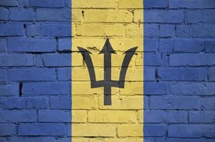 bandeira de barbados é pintada em uma velha parede de tijolos foto