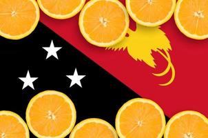 bandeira de papua nova guiné em moldura horizontal de fatias de frutas cítricas foto