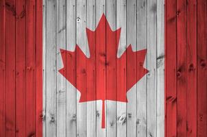 bandeira do canadá retratada em cores de tinta brilhante na parede de madeira velha. banner texturizado em fundo áspero foto