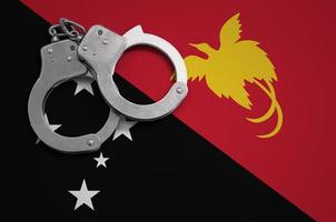 bandeira de papua nova guiné e algemas da polícia. o conceito de crime e delitos no país foto