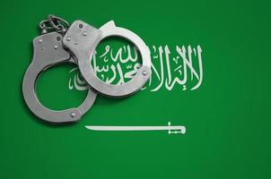 bandeira da arábia saudita e algemas da polícia. o conceito de crime e delitos no país foto