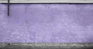 a textura da parede de tijolos de muitas fileiras de tijolos pintados na cor violeta foto