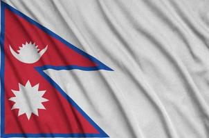 A bandeira do nepal é retratada em um tecido esportivo com muitas dobras. bandeira da equipe esportiva foto