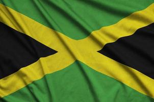 A bandeira da jamaica é retratada em um tecido esportivo com muitas dobras. bandeira da equipe esportiva foto