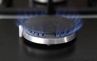 close-up chamas azuis de fogo em um queimador de gás na cozinha para cozinhar. chama de gás em uma caldeira a gás foto