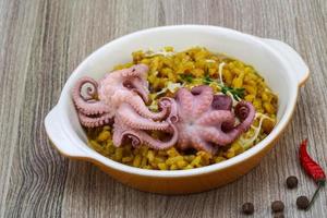 risoto de frutos do mar em uma tigela com fundo de madeira foto