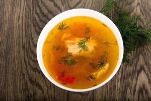 sopa de salmão em uma tigela com fundo de madeira foto