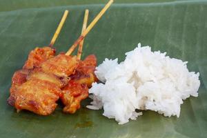 carne de porco grelhada com arroz pegajoso no fundo da folha de bananeira é um alimento que os tailandeses preferem comer. foto