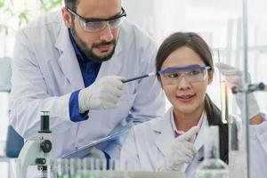 homem-mulher cientista com experiência em laboratório de pesquisa biologia descoberta tubo de ensaio analisando extrato de biotecnologia examinando. estudante de médico aprendendo farmácia médica químico laboratório científico. foto