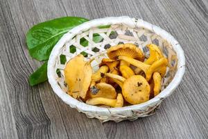 chanterelle em uma cesta em fundo de madeira foto