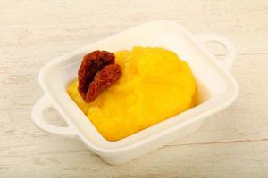 polenta em uma tigela com fundo de madeira foto