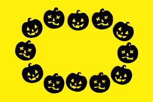 quadro de abóboras de papel preto sobre um fundo amarelo. decorações de férias para o halloween com espaço de cópia. foto