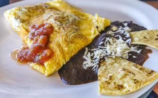 omelete mexicana com feijão preto e nachos na chapa branca. foto