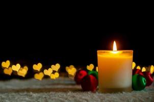 luzes de velas e enfeites de natal com luzes de bokeh de forma de amor dourado. conceito de natal e ano novo. foto