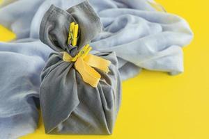 zero desperdício, embrulho ecológico no estilo tradicional japonês furoshiki, conceito ambiental, banner ecológico. cores da moda do ano de 2021 iluminando amarelo e cinza final. foto