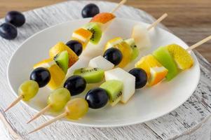 mesa de catering com canapés de salada de frutas. petisco inicial foto