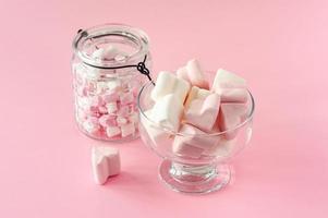 forma de coração de marshmallow e mini com conceito de amor no fundo rosa foto