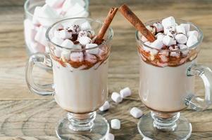 chocolate quente ou bebida de chocolate com marshmallow em caneca de vidro na mesa de madeira. conceito de férias aconchegantes de natal e ano novo, copie o espaço foto