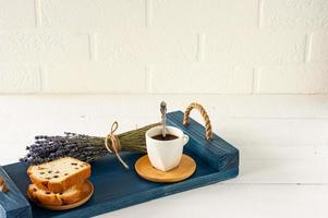 fatias de bolo com passas e uma xícara de café servido em uma bandeja. café da manhã saboroso foto