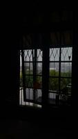 a sombra da janela de dentro do quarto escuro com luz de fora que também está nublada e chuvosa foto