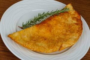 cheburek de carne no prato e fundo de madeira foto