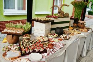 mesa buffet de recepção com frios, carnes e saladas. foto