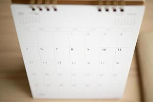 página do calendário fechar no fundo da mesa de madeira conceito de reunião de planejamento de negócios foto