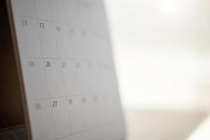página do calendário fechar no fundo da mesa de madeira conceito de reunião de planejamento de negócios foto
