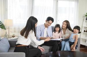 reunião de família asiática com agente imobiliário feminino ou consultor de seguros oferecendo promoções, hipoteca, empréstimo, propriedade e conceito de seguro de saúde médico. foto