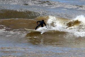 surfando em ondas altas no mar mediterrâneo no norte de israel. foto