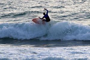 surfando em ondas altas no mar mediterrâneo no norte de israel. foto