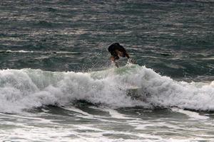 surfando em ondas altas no mar mediterrâneo no norte de israel. foto