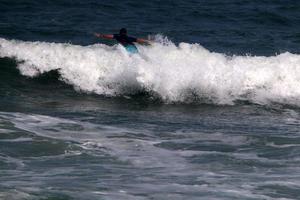 surfando em ondas altas no mar mediterrâneo no norte de israel. foto