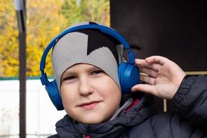 um menino com fones de ouvido na rua foto