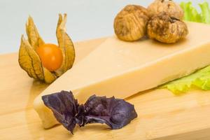 queijo parmesão na placa de madeira e fundo branco foto