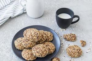 delicioso café da manhã saudável. biscoitos caseiros de aveia em um prato com uma xícara de leite fresco. foto