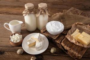 produtos lácteos naturais do agricultor em sortimento em uma mesa de madeira rústica. o conceito de consumo de alimentos naturais. foto