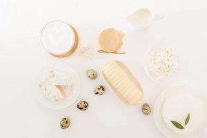 uma variedade de produtos lácteos em uma mesa branca. creme de leite, queijo, requeijão, leite, iogurte. antro de leite. dieta láctea. top view.flat lay. foto