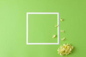 fundo cosmético com flores e moldura branca em verde. postura plana, copie o espaço foto