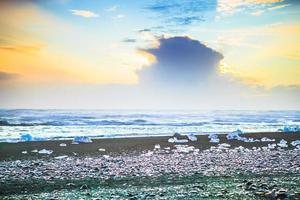 rocha de gelo com praia de areia preta na praia de jokulsarlon, ou praia de diamante, no sudeste da Islândia foto