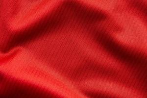 tecido de roupas esportivas vermelho camisa de futebol textura close-up foto