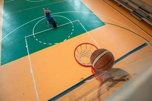 rebocar a foto de um veterano de guerra jogando basquete em uma arena esportiva moderna. o conceito de esporte para pessoas com deficiência