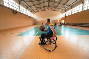 guerra com deficiência ou veteranos de trabalho mistos de raça e idade equipes de basquete em cadeiras de rodas jogando uma partida de treinamento em um ginásio de esportes. conceito de reabilitação e inclusão de pessoas com deficiência. foto