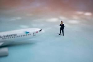 figuras em miniatura de um empresário de sucesso com fundo de transporte aéreo. foto
