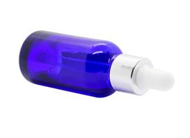 frasco de soro conta-gotas de vidro azul no fundo branco foto