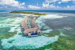 incrível praia da ilha. maldivas de vista aérea tranquila paisagem tropical à beira-mar com palmeiras na praia de areia branca. costa de natureza exótica, ilha de resort de luxo. belo turismo de férias de verão foto