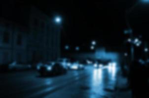 cena noturna turva de tráfego na estrada. imagem desfocada de carros viajando com faróis luminosos. arte bokeh foto